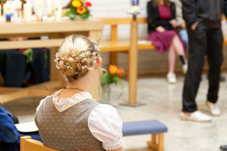 Konfirmandin mit Blumen im geflochtenen Haar